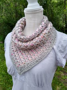 a white mannequin wearing a gray and pink scarf