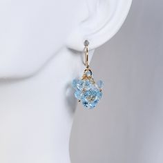 Small scale dangly pair for any occasion created in a monochromatic  blue hue. these earrings feature beautiful, faceted, sky blue roundels of blue topaz made into attractive cluster. Completed with simple, gold filled ear wires.  1inch tall top to bottom.  Sweet, subtle color these dangles will add a touch of glow and shimmer to any outfit. Perfect gift for any occasion, birthday, graduation, Mothers's Day ...  Adorn yourself or someone you love! This style can be made in sterling silver and wi Elegant Light Blue Crystal Earrings For Gift, Blue Briolette Earrings For Wedding, Blue Briolette Jewelry For Party, Elegant Aquamarine Earrings With Ear Wire, Anniversary Blue Topaz Briolette Earrings, Monochromatic Blue, Gift For Wife Birthday, Topaz Jewelry, Wife Birthday