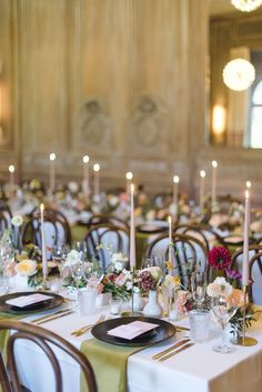 a long table with many place settings and candles