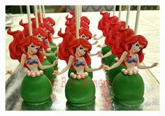 the little mermaids are sitting on top of each other in green vases with candles