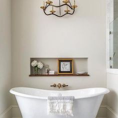 a white bath tub sitting under a chandelier