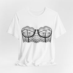 Add a playful twist to your wardrobe with this Lingerie Bra Print Graphic T-shirt! This fun and trendy tee is perfect for adding a touch of whimsy to your everyday outfit or for a bachelorette party. Made from soft and comfortable fabric, this unique graphic tee is sure to turn heads and be a conversation starter wherever you go. Upgrade your style with this eye-catching piece! Graphic Tee With Heart Print And Short Sleeves, Short Sleeve Graphic Tee With Heart Graphic, White Graphic Tee Jersey T-shirt, White Graphic Tee With Heart Print, Corset Graphic Tee, Black Corset, Trendy Tee, Tshirt Outfits, Bra Lingerie