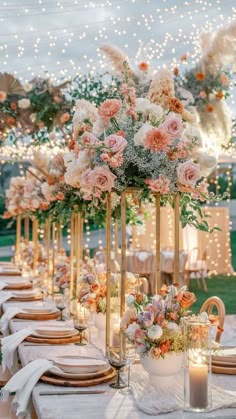 a table set up with flowers and candles for an outdoor dinner party or wedding reception