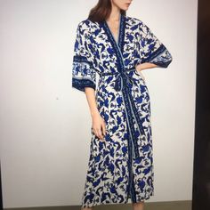 A Lightweight Woven Wrap With Ornate Floral Print And Sash Tie Belt At The Waits Sash Tie Belt At Waist 100% Polyester Plain Weave Machine Wash Imported Elegant Blue Floral Print Kimono, Chic Long Sleeve Kimono For Brunch, Blue Floral Print Outerwear For Vacation, Blue V-neck Outerwear For Spring, Blue V-neck Spring Outerwear, Blue Long Sleeve Kimono For Daywear, Long Sleeve Blue Kimono For Daywear, Blue Kimono For Spring Daywear, Blue Spring Kimono For Daywear