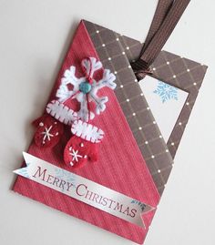 a christmas ornament hanging from a ribbon on top of a piece of paper