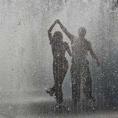 two people are dancing in the rain