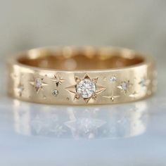 a gold ring with stars and diamonds on it