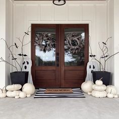 the front door is decorated for halloween with fake pumpkins