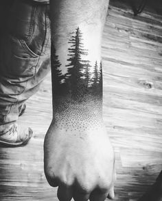 a man's arm with trees on it, and dots in the forest tattoo