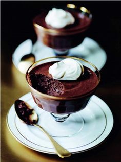 two desserts are sitting on plates with spoons