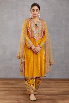 Topaz yellow long kurta with placement geometric motif embroidery. Comes with printed pants and silk organza dupatta.
Component: 3
Printed, Embroidered
Neckline: Round
Sleeve Length: Full
Fabric: Kurta: Velvet, handwoven chanderi,  cotton silk, voile; Pant: velvet, cotton silk, voile, Silk Organza; Dupatta: Pure silk organza, cotton silk, handwoven chanderi
Color: Yellow
Side slit
Split neck
Tassel detail
 - Aza Fashions Yellow Kurta, Velvet Embroidery, Indian Bride Outfits, Designer Punjabi Suits, Velvet Dress Designs, Latest Dress Design, Simple Kurta Designs, Pakistani Wedding Outfits, Organza Dupatta