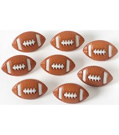 six footballs are arranged in the shape of an american football on a white background