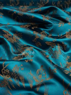 a blue and gold fabric with floral designs on the bottom, in very close up