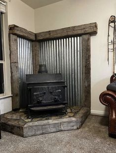 an old fashioned stove sitting in a living room next to a leather chair and window