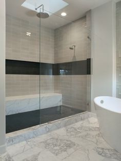 a bath room with a tub and a glass shower door next to it's walls