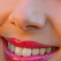 a close up of a woman's face with white teeth and pink lip polish