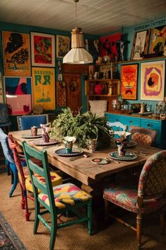 a dining room table with colorful chairs and pictures on the wall in the back ground