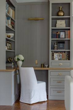 a white chair sitting in front of a book shelf