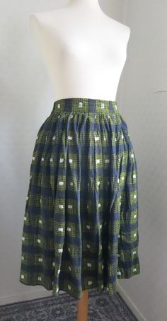 "Size Small. Skirt made between the the 30s to 50s with a cool plaid pattern in the colors black, green and white. The fabric is a thick, cozy cotton flannel. The look of the skirt is kind of 50s but I think the skirt could be much older, and maybe altered in the 50s. It has no closures, but I added two hooks and thread loops to make it fit on the mannequin. No other flaws that I can see. Waist: 66 cm - 26 in Hip: Free Length: 71 cm - 23 in Tracking is not included in the price because of the hi Fitted Cotton Plaid Skirt, Vintage Plaid Cotton Skirt, Retro Plaid Cotton Skirt, Fitted Cotton Gingham Skirt, Retro Gingham Cotton Skirt, Small Skirt, Green Flannel, The 50s, Up Girl