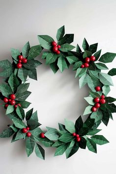 a wreath made out of green leaves and red berries