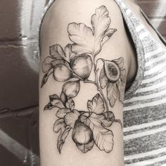 a woman's arm with flowers and leaves on it