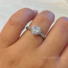 a woman's hand with a diamond ring on top of her finger and an engagement band