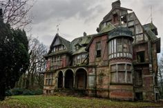 an old abandoned house with lots of windows and ivy growing on the side of it