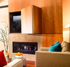 a living room filled with furniture and a flat screen tv mounted to the wall above a fireplace