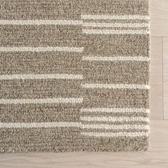 an area rug on the floor with white and brown stripes in between it's edges