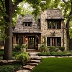 a stone house surrounded by trees and grass