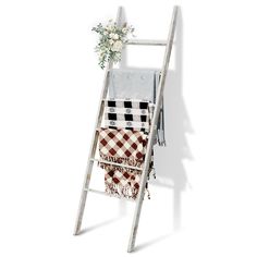 a white ladder with towels and flowers on it