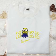 Minion x Nike Embroidered Shirt, Cartoon Embroidered Hoodie, Nike Inpsired Embroidered Sweatshirt White Sweatshirt With Machine Embroidery For Streetwear, Cotton Sweatshirt With Machine Embroidery For Streetwear, Machine Embroidered Cotton Sweatshirt For Streetwear, White Hooded Top With Machine Embroidery, Crew Neck Hoodie With Machine Embroidery For Streetwear, Sporty Cotton Sweatshirt With Machine Embroidery, College Embroidered Hoodie Tops, Hooded Sweatshirt With Machine Embroidery For Streetwear, White Cotton Sweatshirt With Embroidered Patch