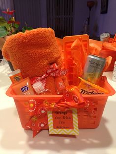 an orange basket filled with items on top of a table