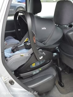 the interior of a small car with its seat folded down and two baby seats in it