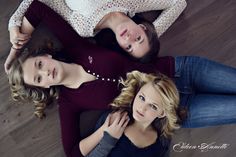 three women laying on the floor with their arms around each other and looking up at the camera