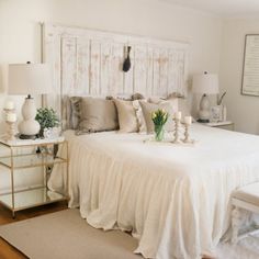 a bed with white sheets and pillows in a room