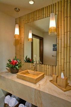 a bathroom with two sinks and mirrors in front of bamboo wall coverings on the walls