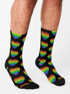 a man wearing black socks with rainbow hearts on them