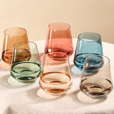 four different colored glasses sitting on top of a table