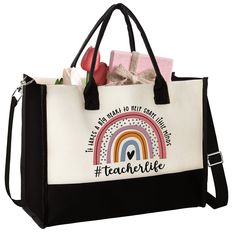 a black and white tote bag with an embroidered rainbow on the front, saying teachlife