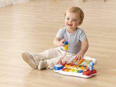 a young boy sitting on the floor playing with toys