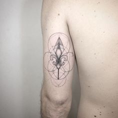 a man's arm with a tattoo on it that has a fleur de lis in the middle