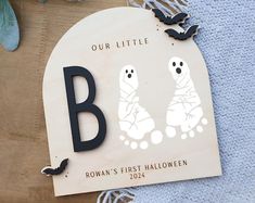 a wooden sign that says our little b is for rowan's first halloween