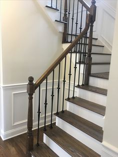 a staircase with wooden handrails and white walls