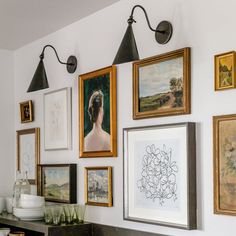 the wall is covered with many framed pictures and art on it's sidewall