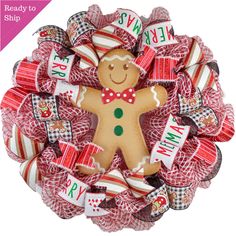 a christmas wreath with a gingerbread man in the center and red ribbon around it