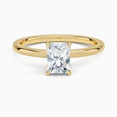 a yellow gold ring with a princess cut diamond