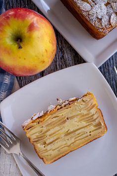 a piece of cake sitting on top of a white plate next to an apple and fork