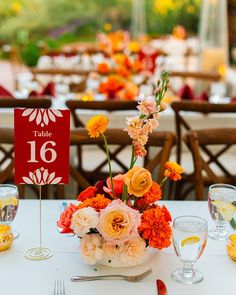 the table is set with flowers and place cards