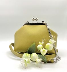 Small Leather Handbag in a Kiss Lock metal frame and with a decorative chain is a fashionable  must have in Your Collection. The combination Green-Yellow color Leather and Leather strap with decorative chain makes it Unique. This Handbag is one of a kind and great for Everyday use. Beautiful Cotton lining and two Pockets inside. Perfect for your cell phone, wallet, makeup and keys. Ready to Ship. 100% Handmade. BAG MEASUREMENTS Height: 5,5" Width: 7" bottom Depth: 4" Strap Drop: 23" NOT adjustable, removable Silver Metal Frame with screws and Ball clasp 5,7" Real colors may slightly differ. Made with love in my home Workshop. I love this bag! The Price of this Leather bag is Without Flowers. You can find more of my Handmade Bags here https://www.etsy.com/shop/FlowDream?ref=simple-shop-head Gift Satchel Evening Bag With Chain Strap, Chain Strap Satchel Evening Bag Gift, Evening Satchel Bag With Chain Strap As A Gift, Yellow Box Bag With Detachable Handle For Evening, Gift Shoulder Bag With Silver-tone Hardware, Silver-tone Hardware Shoulder Bag As Gift, Elegant Green Pouch Satchel, Yellow Evening Shoulder Box Bag, Yellow Shoulder Box Bag For Evening